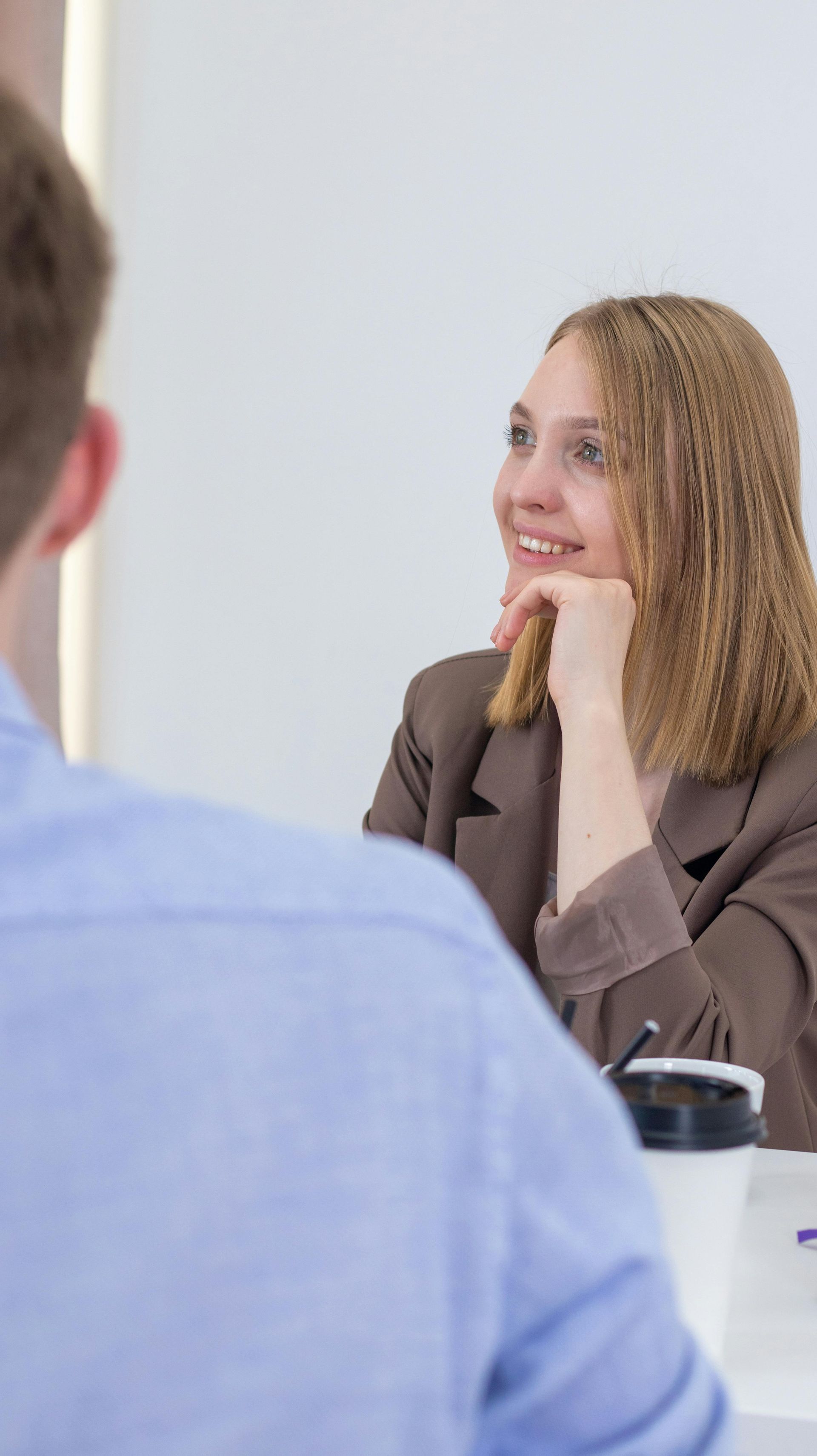 A man and a woman are sitting at a table having a conversation.