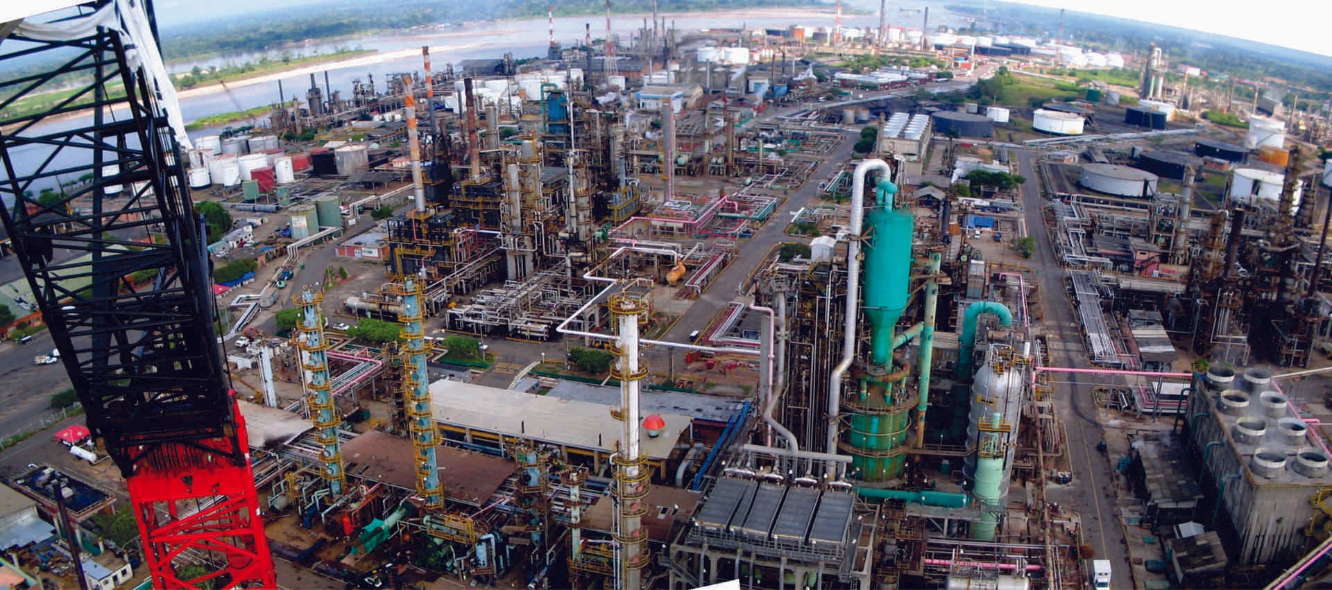 Una vista aérea de una gran refinería de petróleo con un río al fondo.