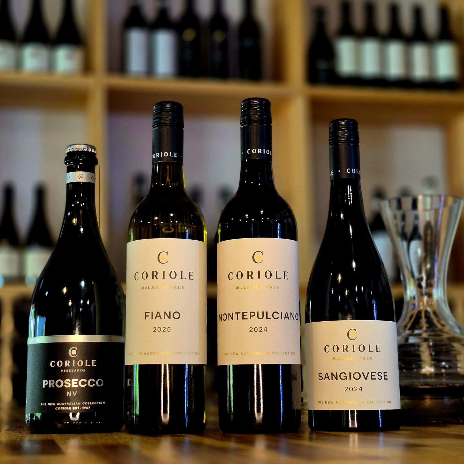 Several bottles of wine are lined up on a wooden table