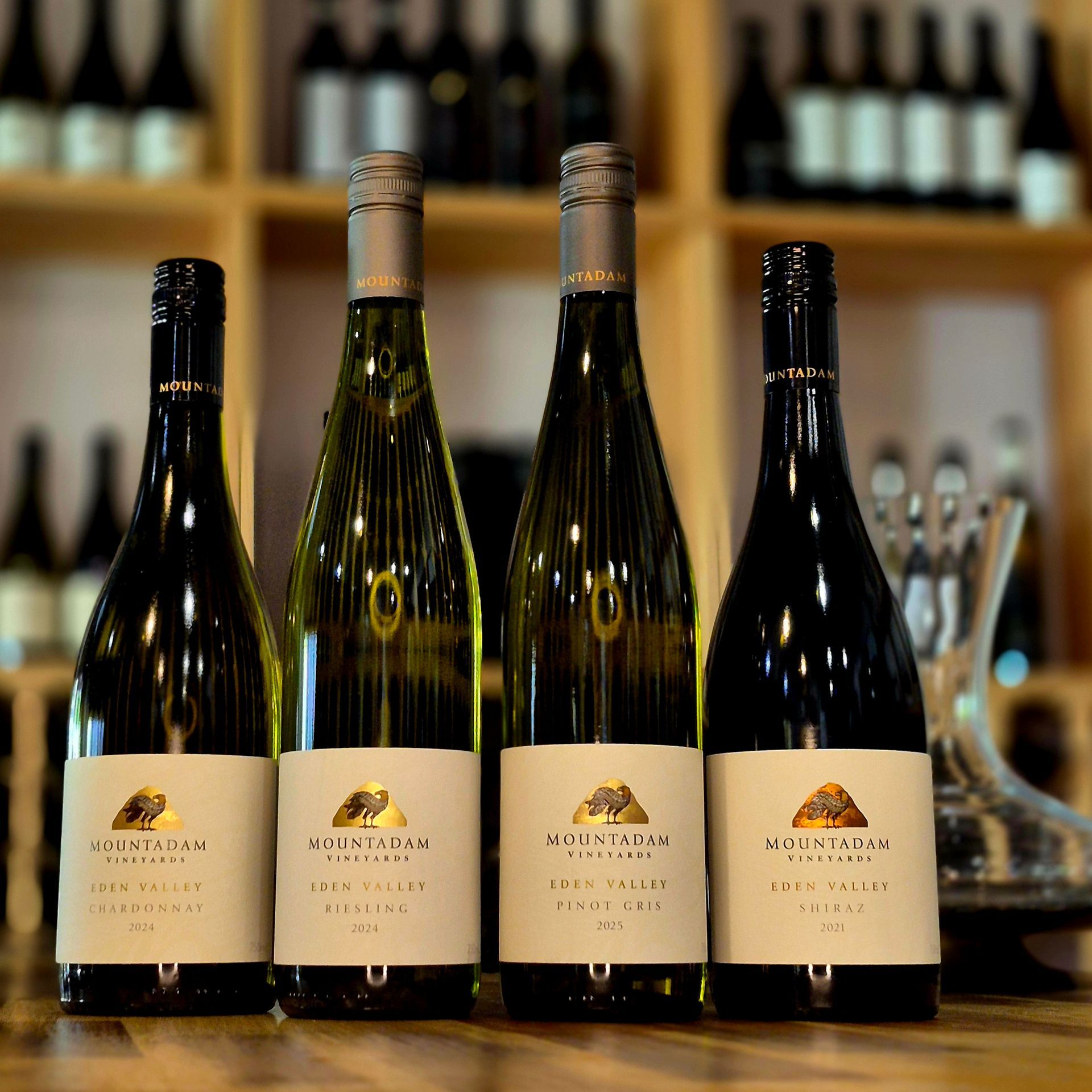 Five bottles of murray street wine are lined up on a wooden table