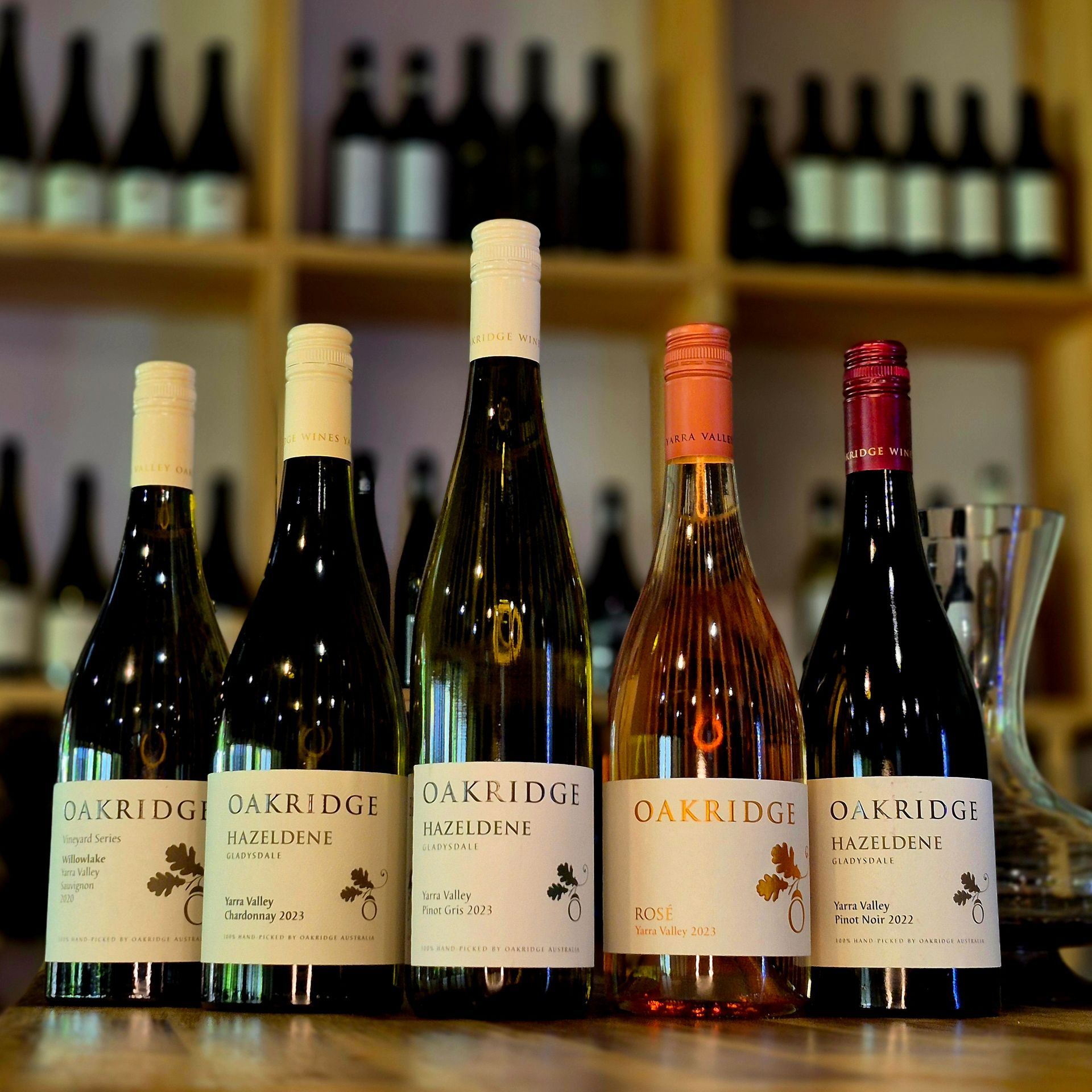 Oakridge wine bottles are lined up on a wooden table