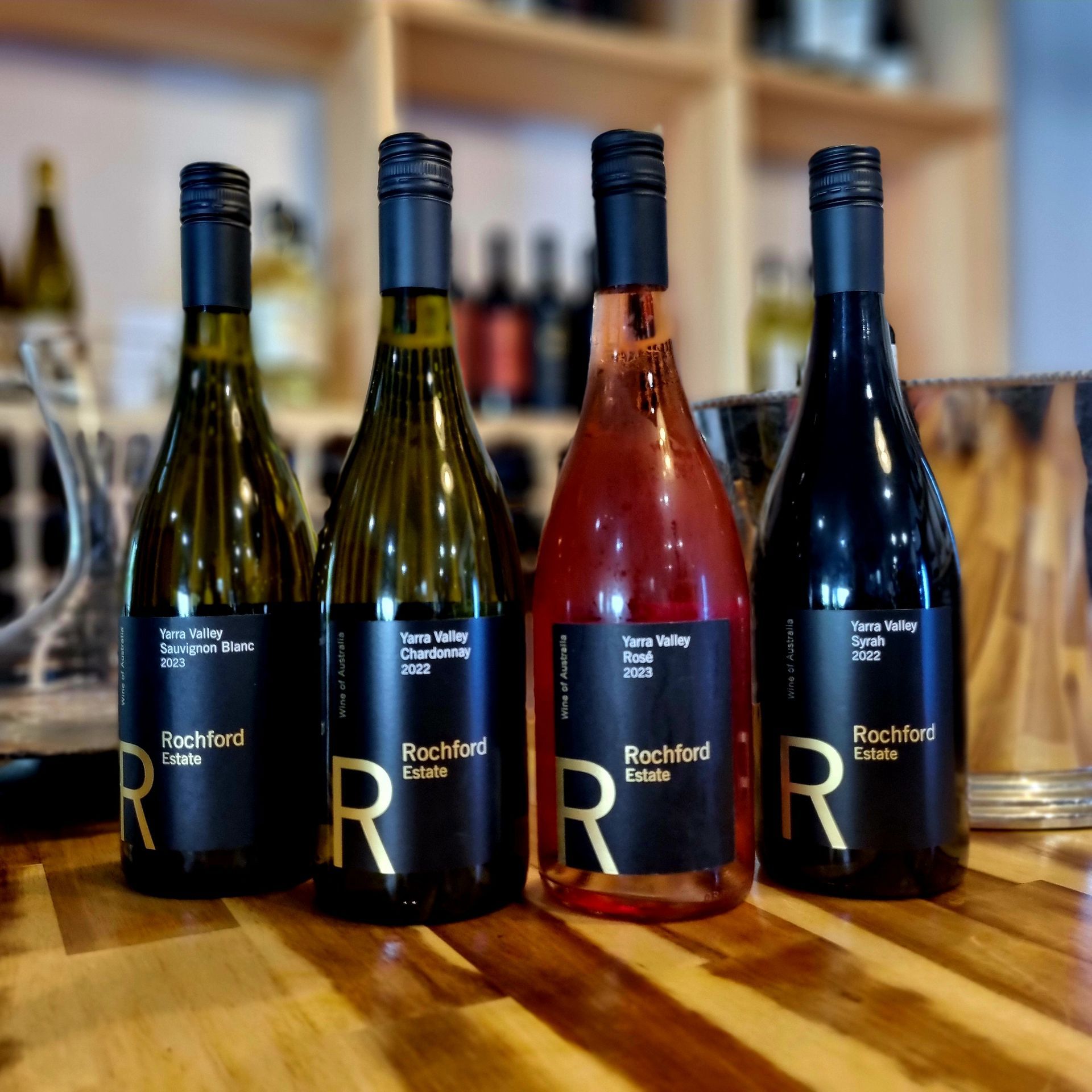 Four bottles of rachford wine are lined up on a wooden table