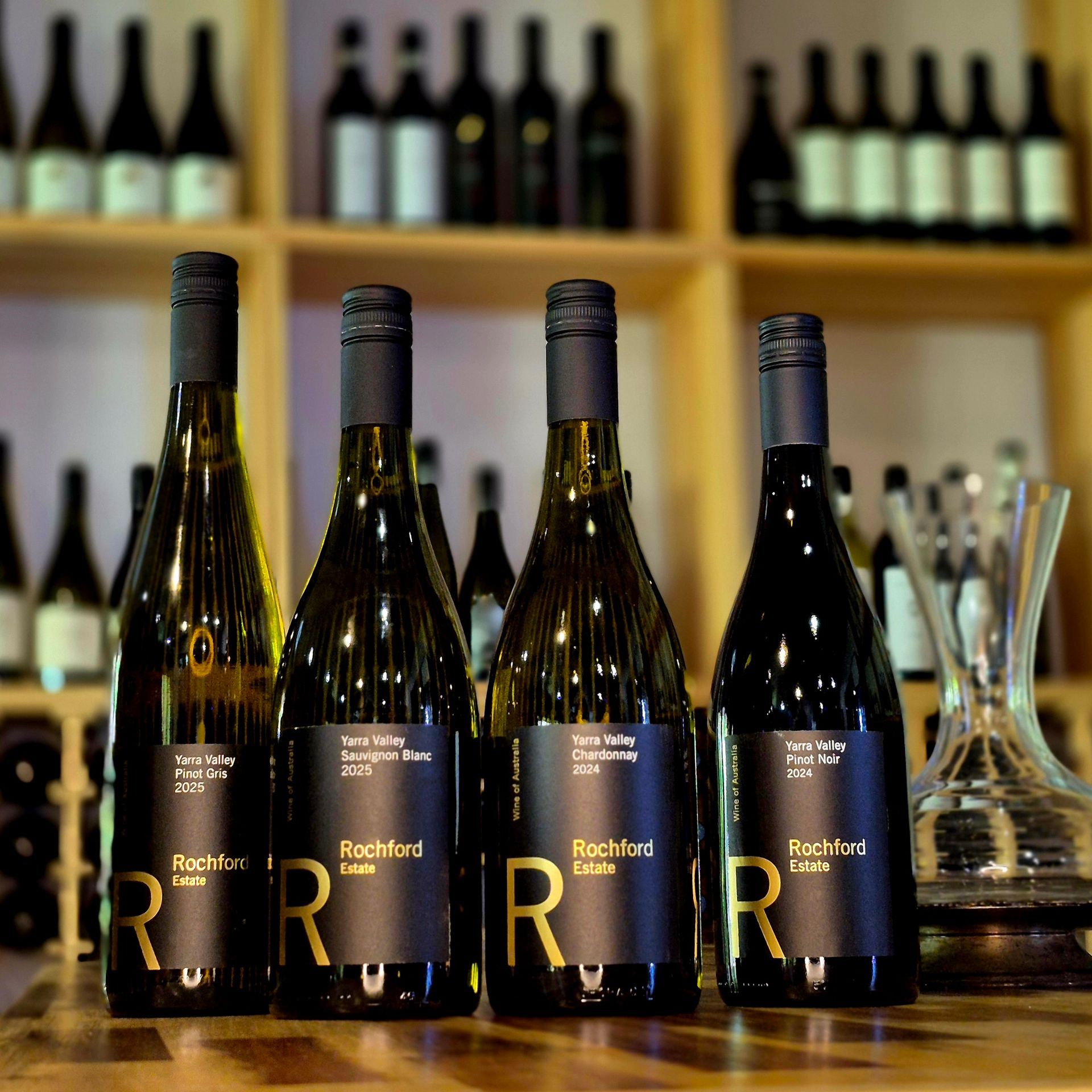 Four bottles of rachford wine are lined up on a wooden table