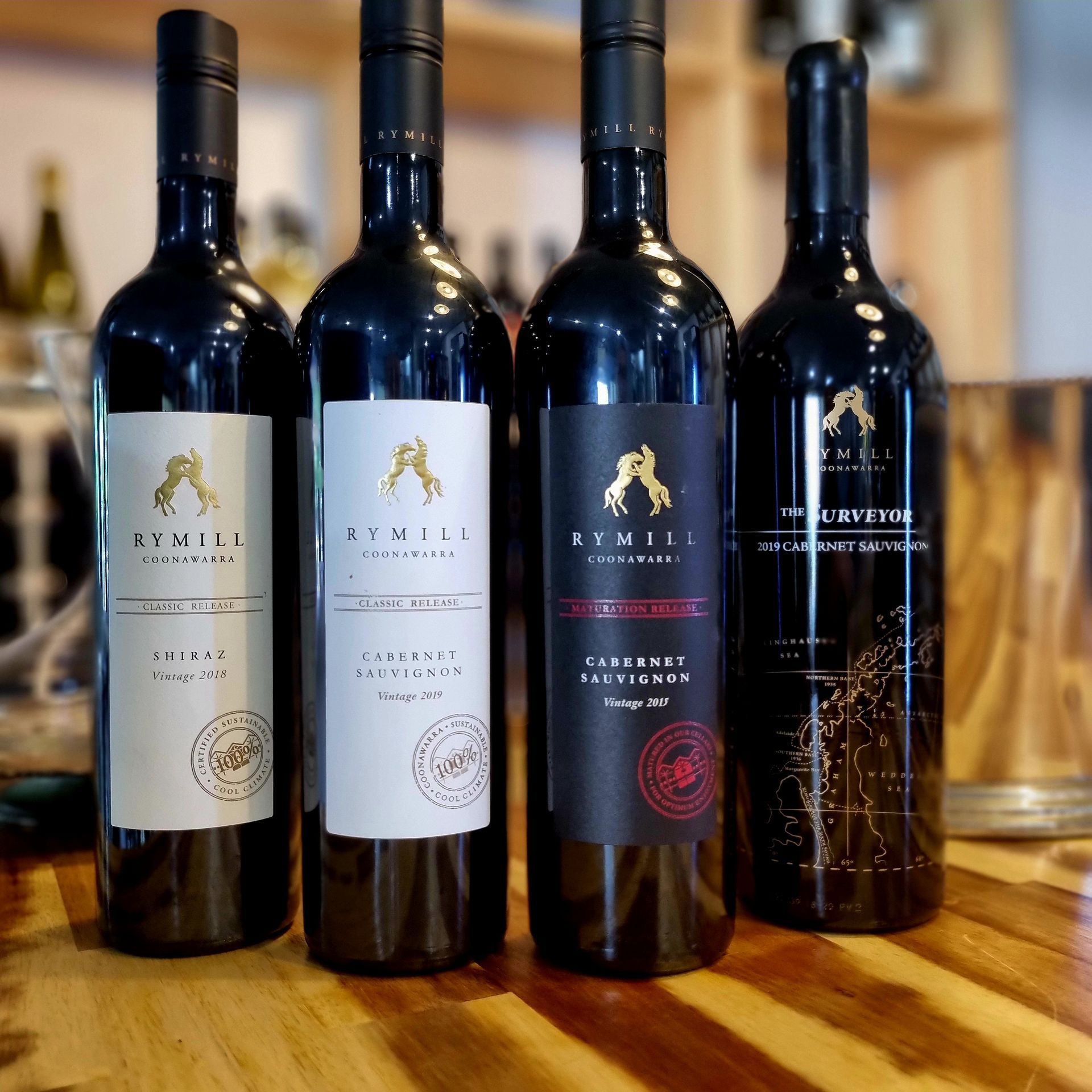 Four bottles of rymill wine are lined up on a wooden table