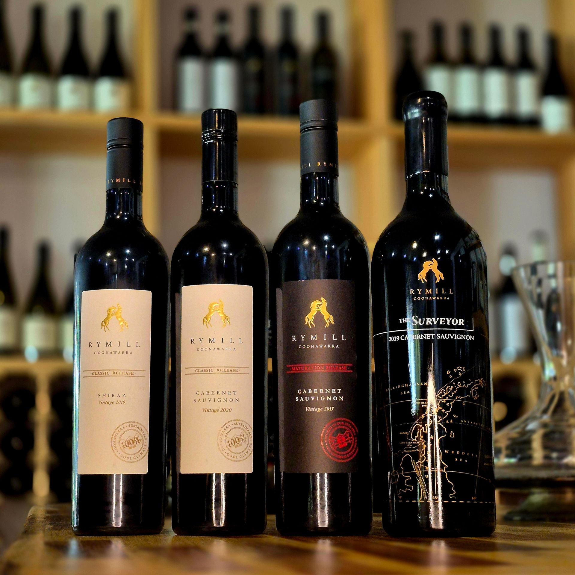 Four bottles of rymill wine are lined up on a wooden table