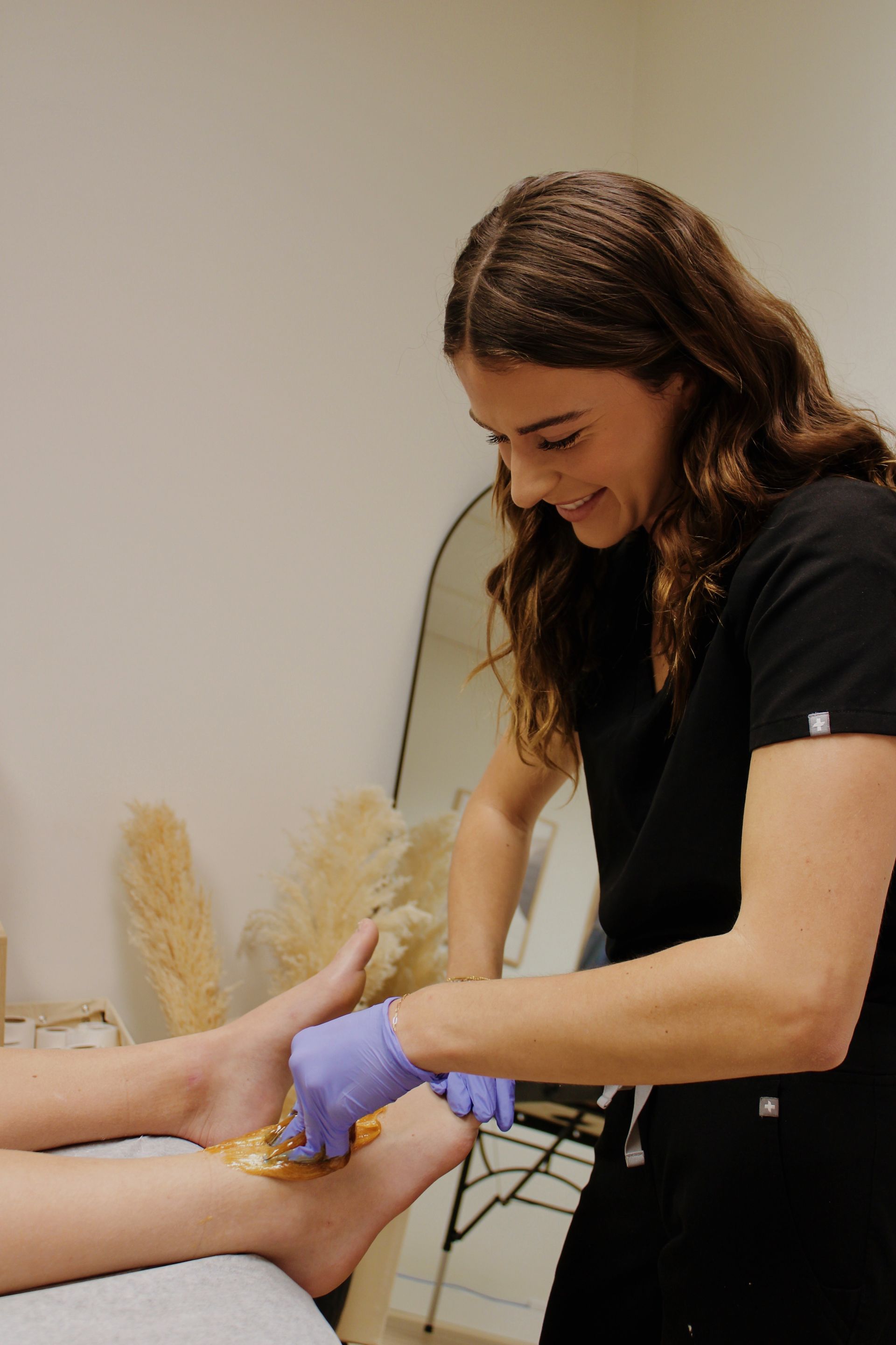 A woman is getting her legs waxed in a beauty salon.