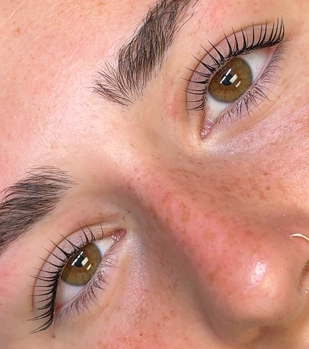 A woman is getting her eyelashes done at a beauty salon. A woman is getting her eyelashes done at a beauty salon.