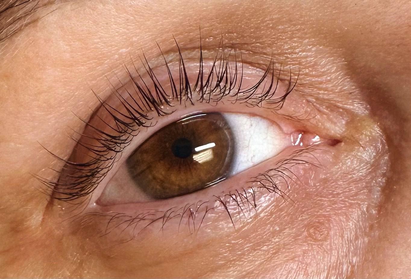 A woman is getting her eyelashes done at a beauty salon. A woman is getting her eyelashes done at a beauty salon.