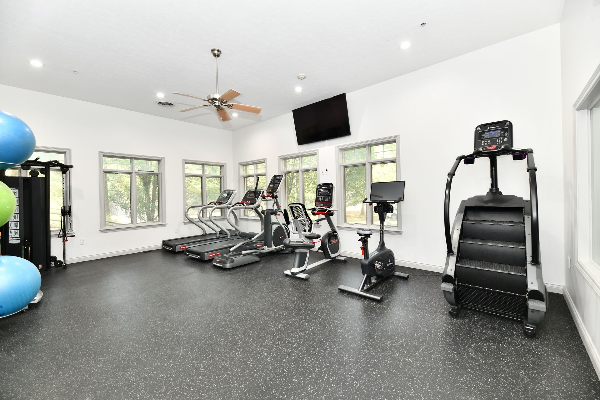 An empty living room with hardwood floors and sliding glass doors leading to a balcony.