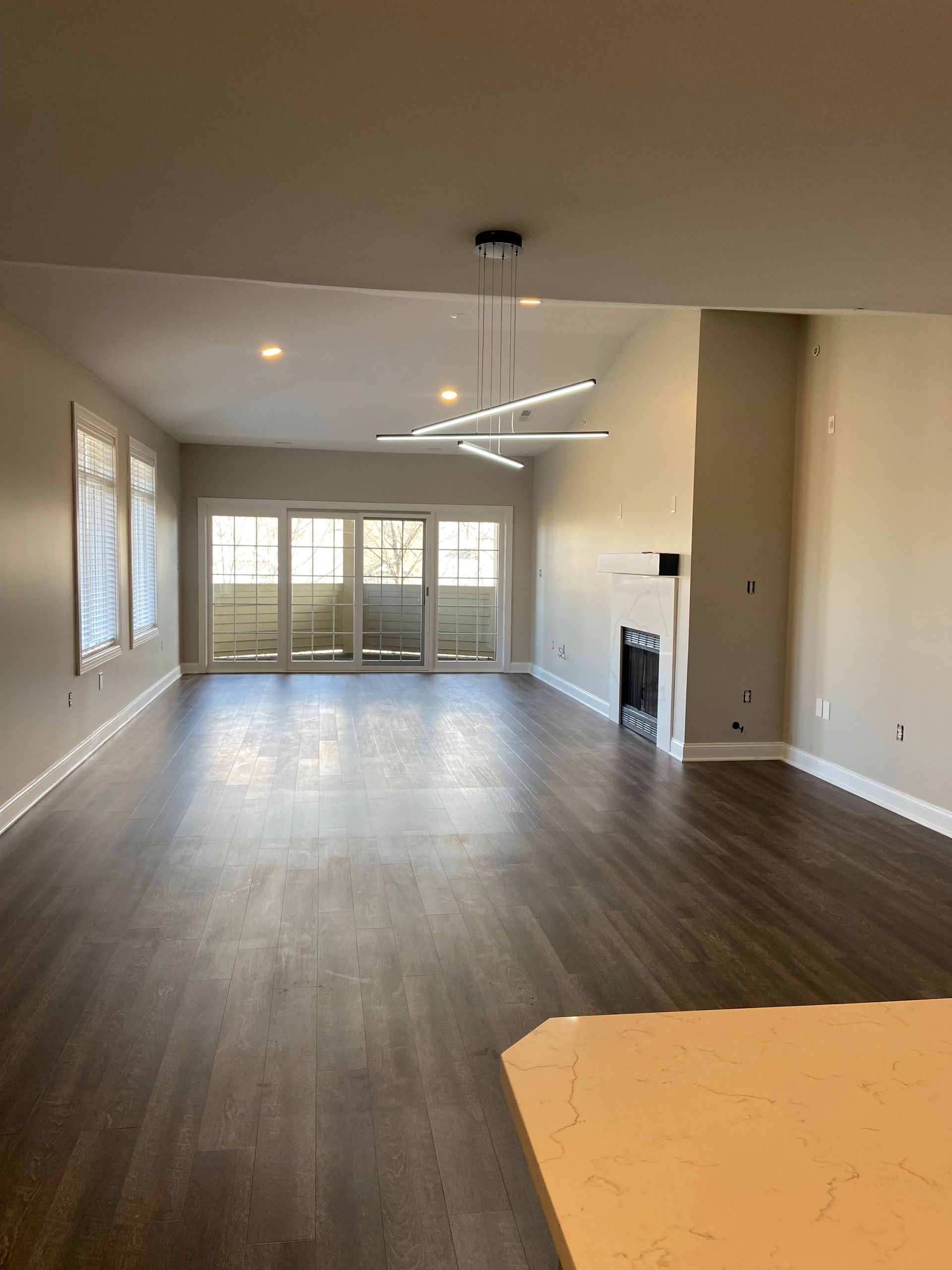 A large empty living room with hardwood floors and a fireplace.