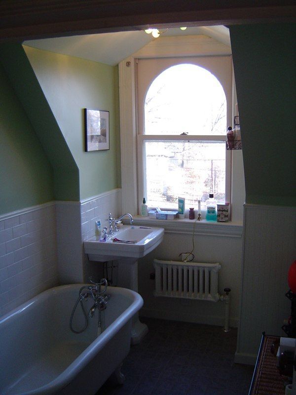 Bathroom with a double vanity, tall storage cabinet, and walk-in shower with decorative glass panel.