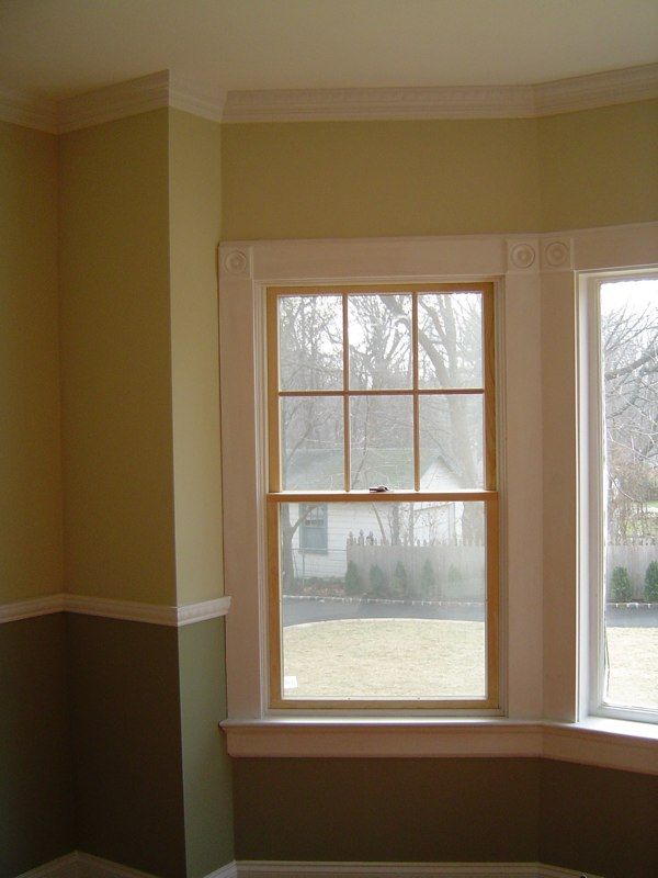 Person wearing gloves installing grey tile with mortar.