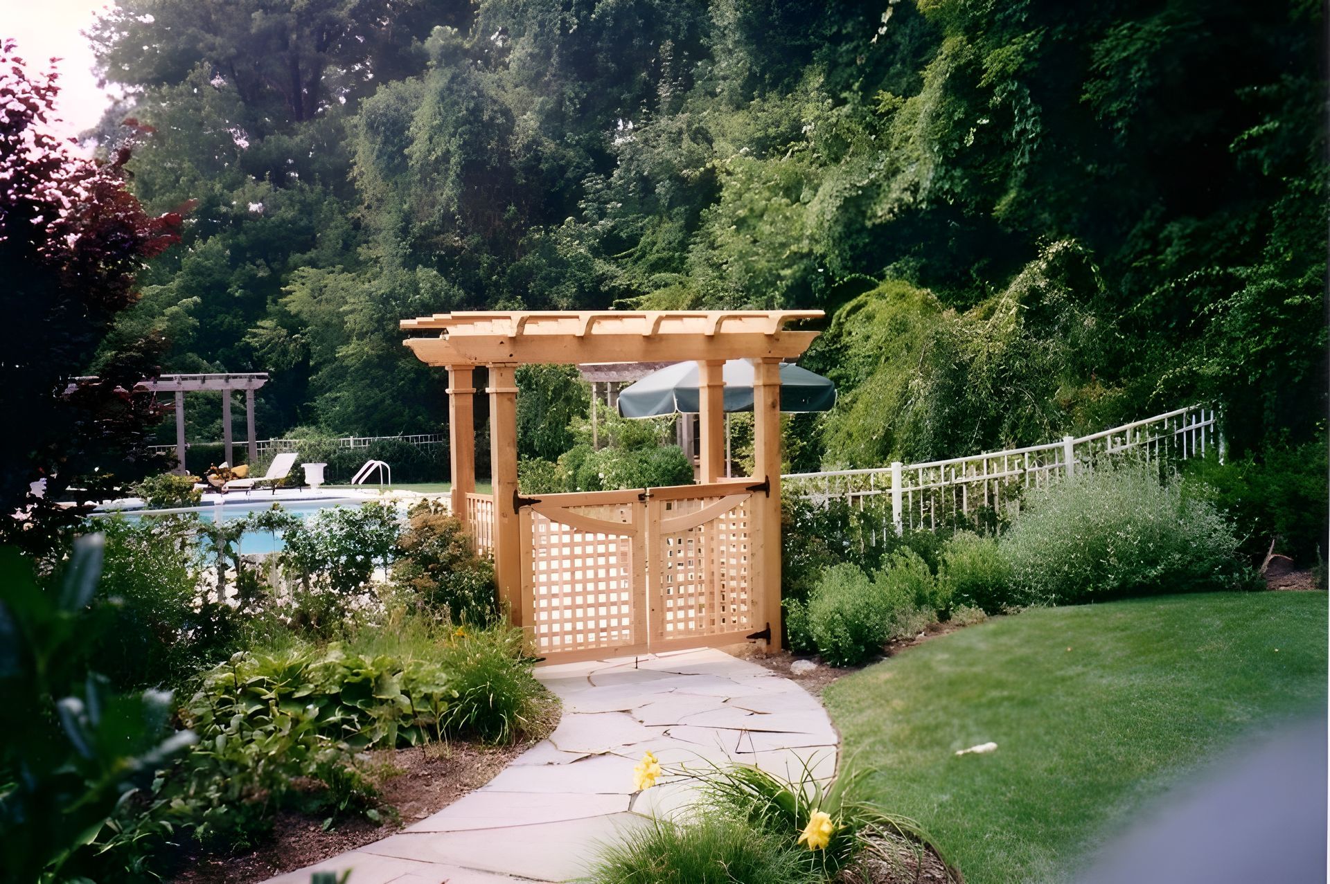 Person examining wood planks on a workbench with tools, wearing an apron, in a workshop.