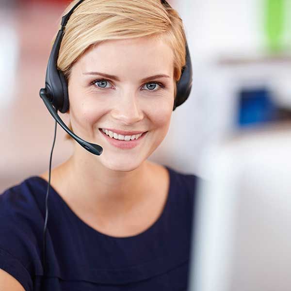 A woman wearing a headset is smiling and looking at the camera