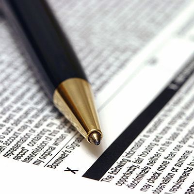 A pen rests on a piece of paper with the letter x on it