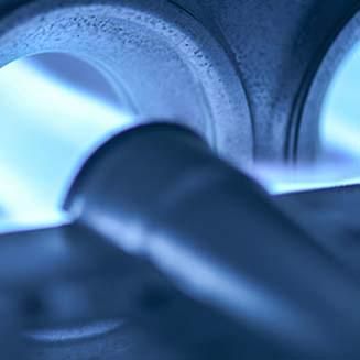 A close up of a gas burner with blue flames coming out of it.
