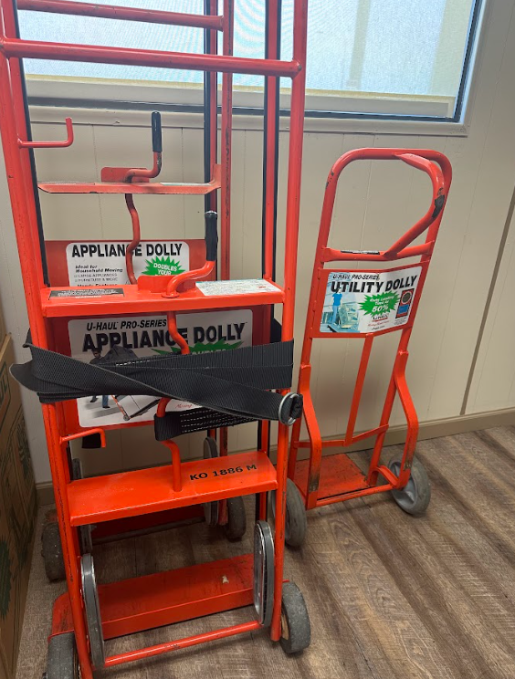 Two orange metal dollies, one labeled 