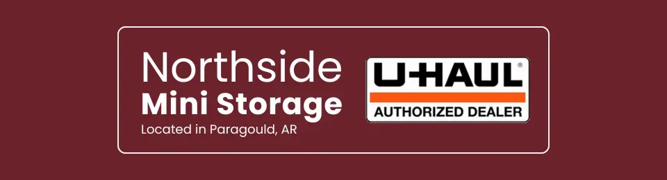 A maroon sign for Northside Mini Storage in Paragould, AR, which is also an authorized U-Haul dealer.