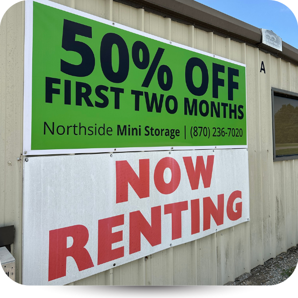 A wall-mounted sign at Northside Mini Storage offering 50% off for the first two months and stating 