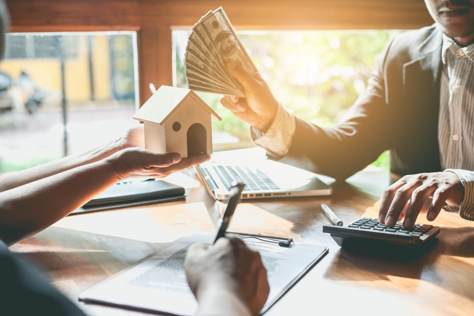 A man is giving a woman a model house and money.