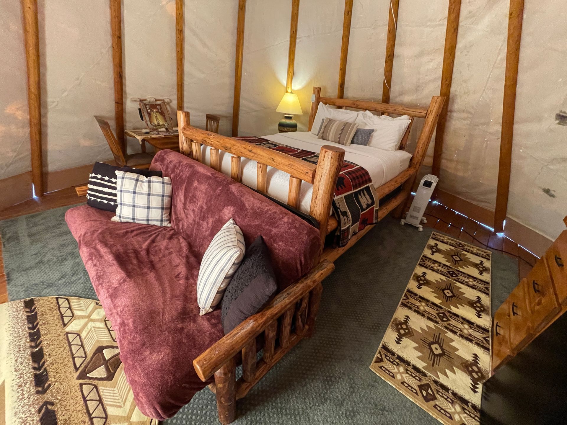 Interior of glamping tipi with queen bed and full fold out futon sofa