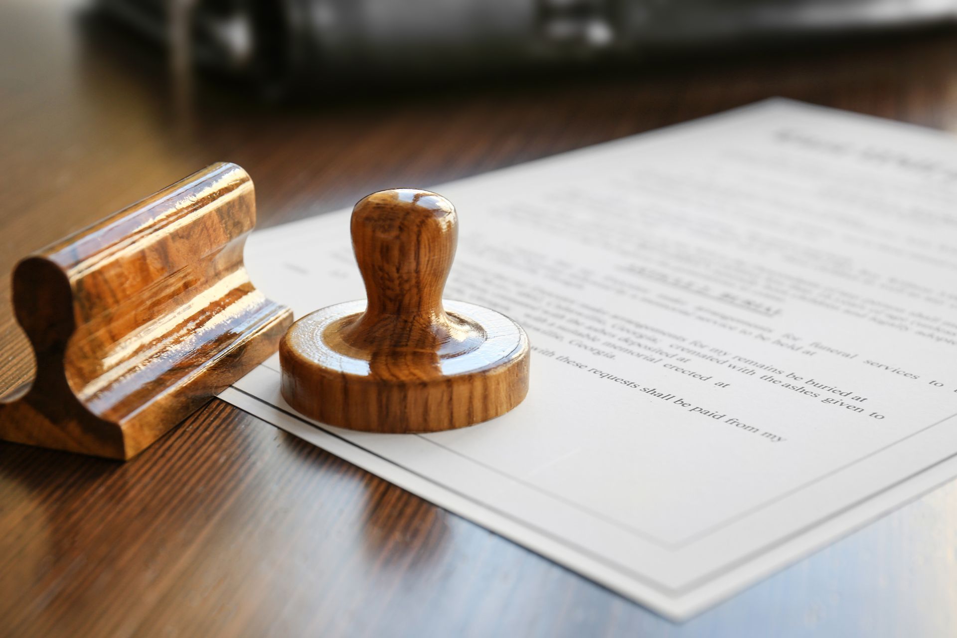 A woman is putting a stamp on a piece of paper.
