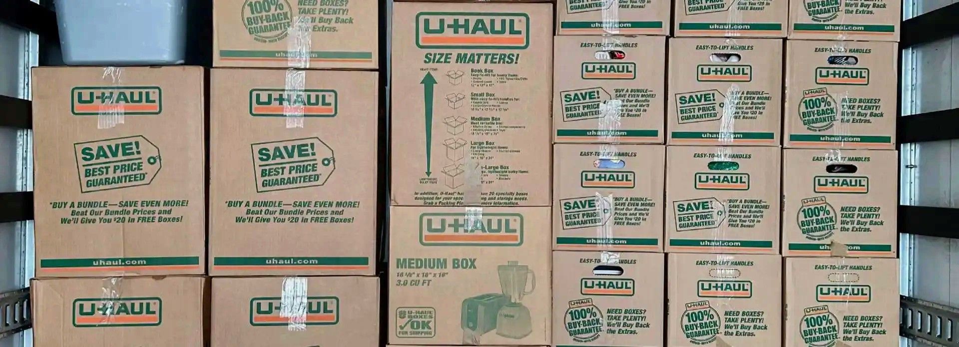 A bunch of u-haul boxes are stacked on top of each other.