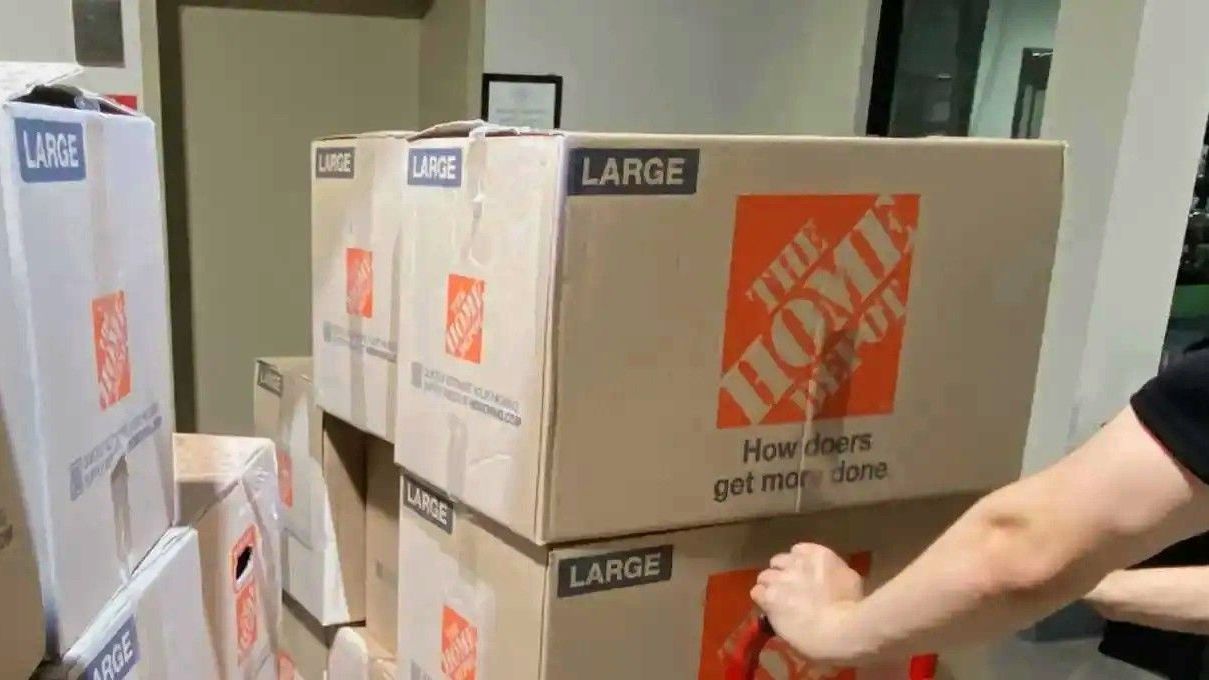 A person is pushing a large home depot box
