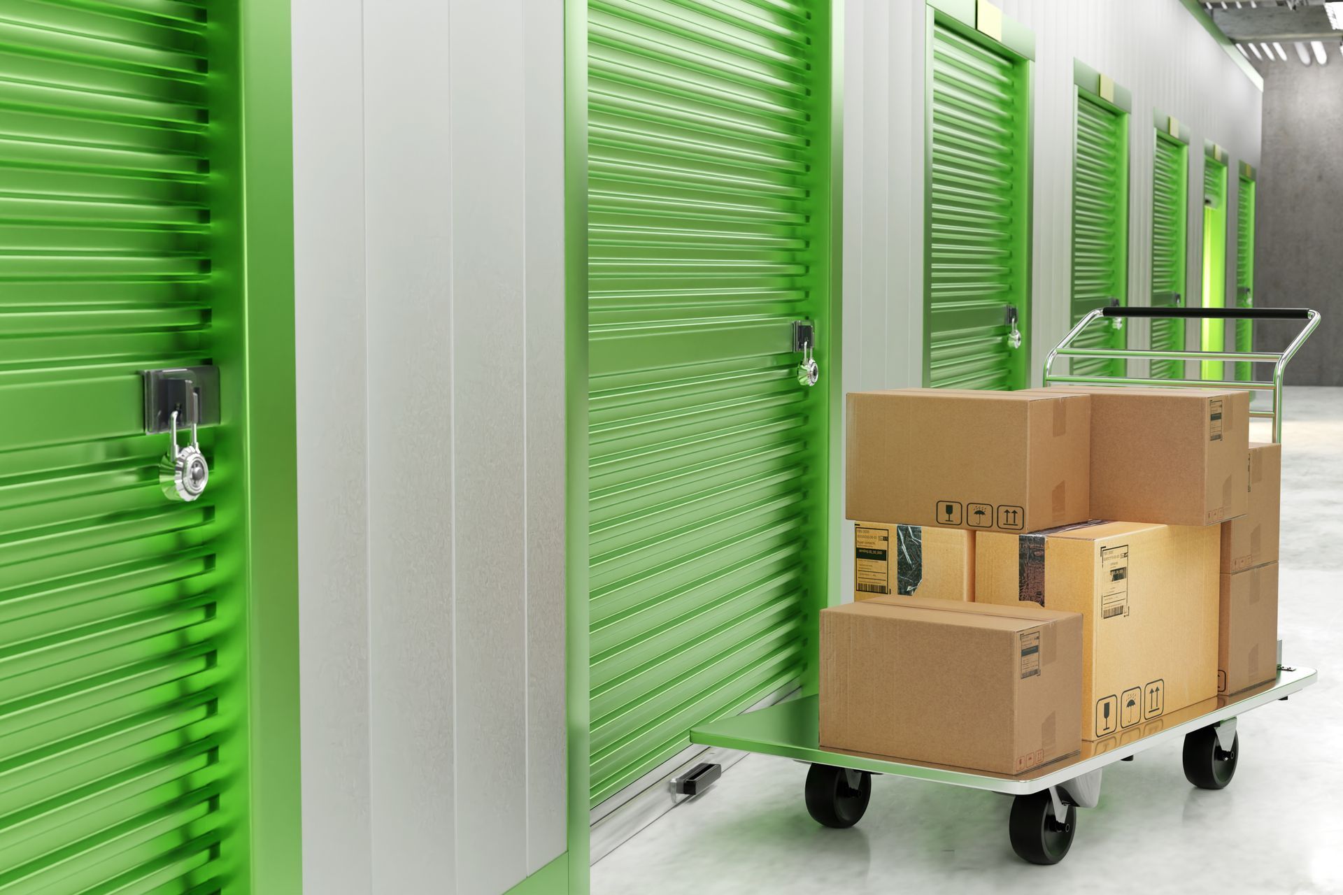 Boxes on a cart in front of green storage units; indoors, bright lighting.