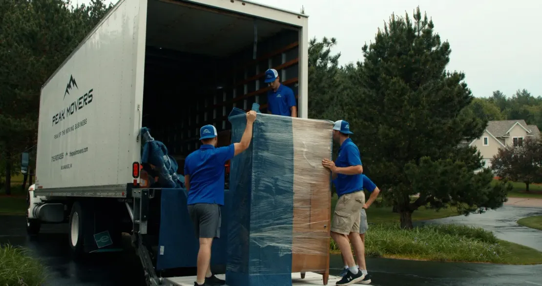 A group of men are loading furniture into a moving truck.