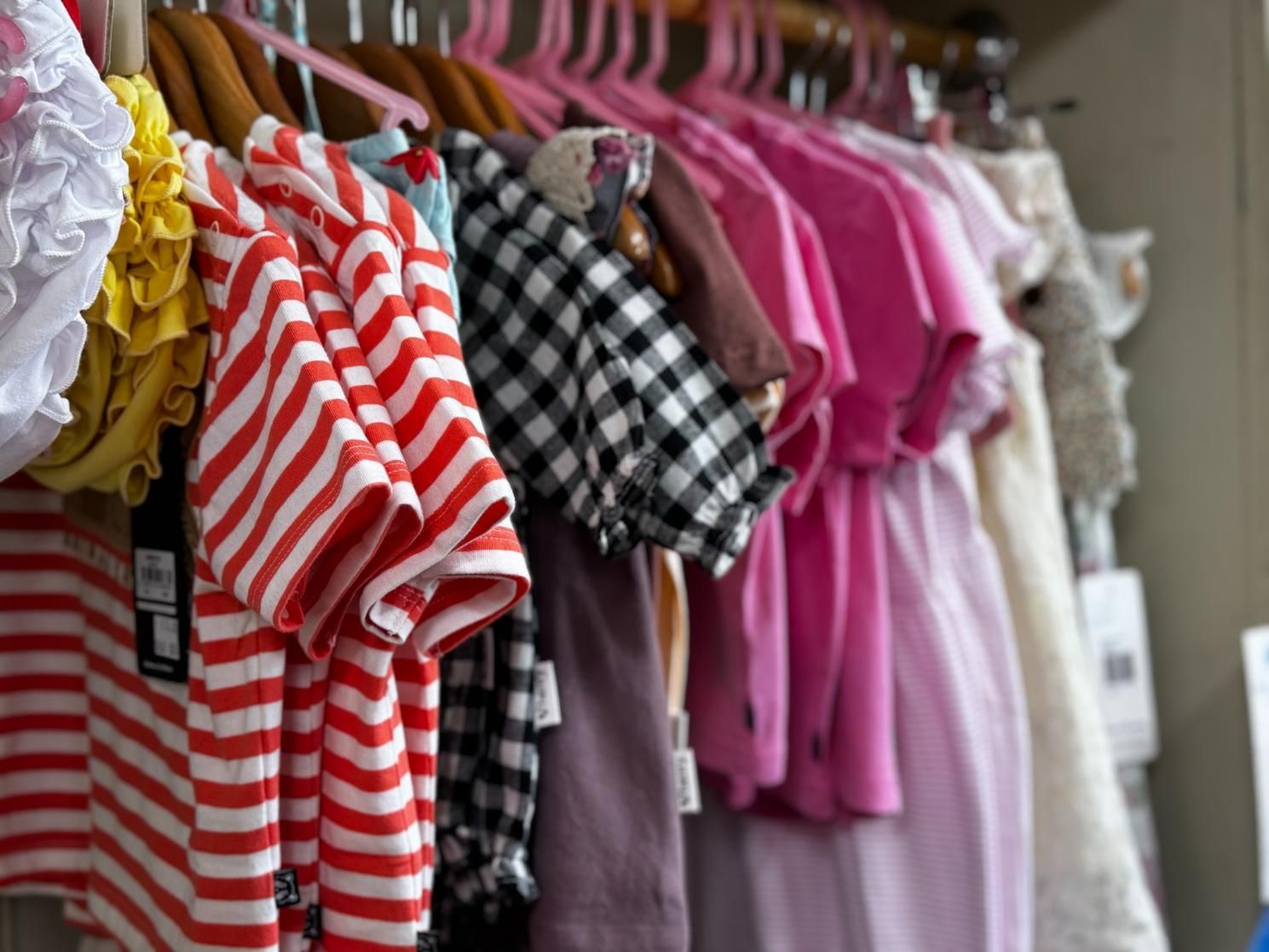 A Bunch Of Clothes Are Hanging On A Rack In A Store — Beach Time Trading Co In Yeppoon, QLD