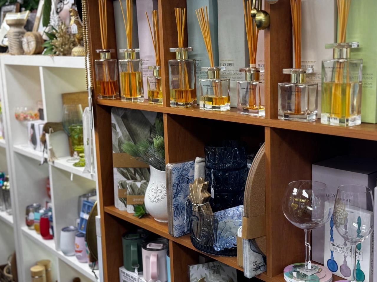 A Shelf Filled With Lots Of Bottles Of Perfume And Wine Glasses — Beach Time Trading Co In Yeppoon, QLD