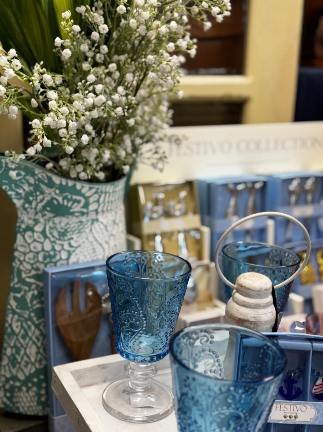 A Vase Of Lily Of The Valley Flowers Is Sitting Next To Two Blue Wine Glasses — Beach Time Trading Co In Yeppoon, QLD