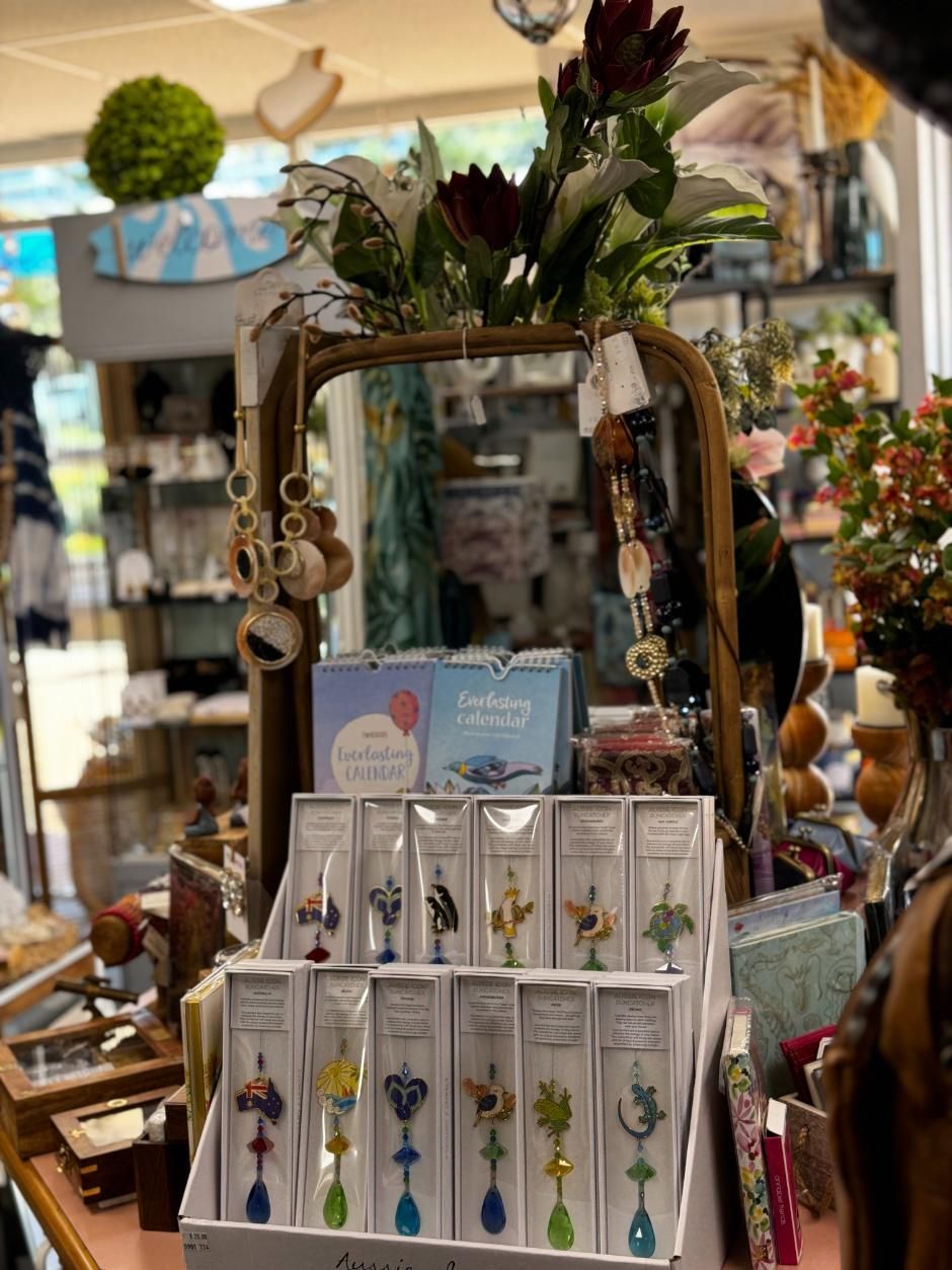 A Display Of Jewelry In A Store With A Vase Of Flowers In The Background — Beach Time Trading Co In Yeppoon, QLD