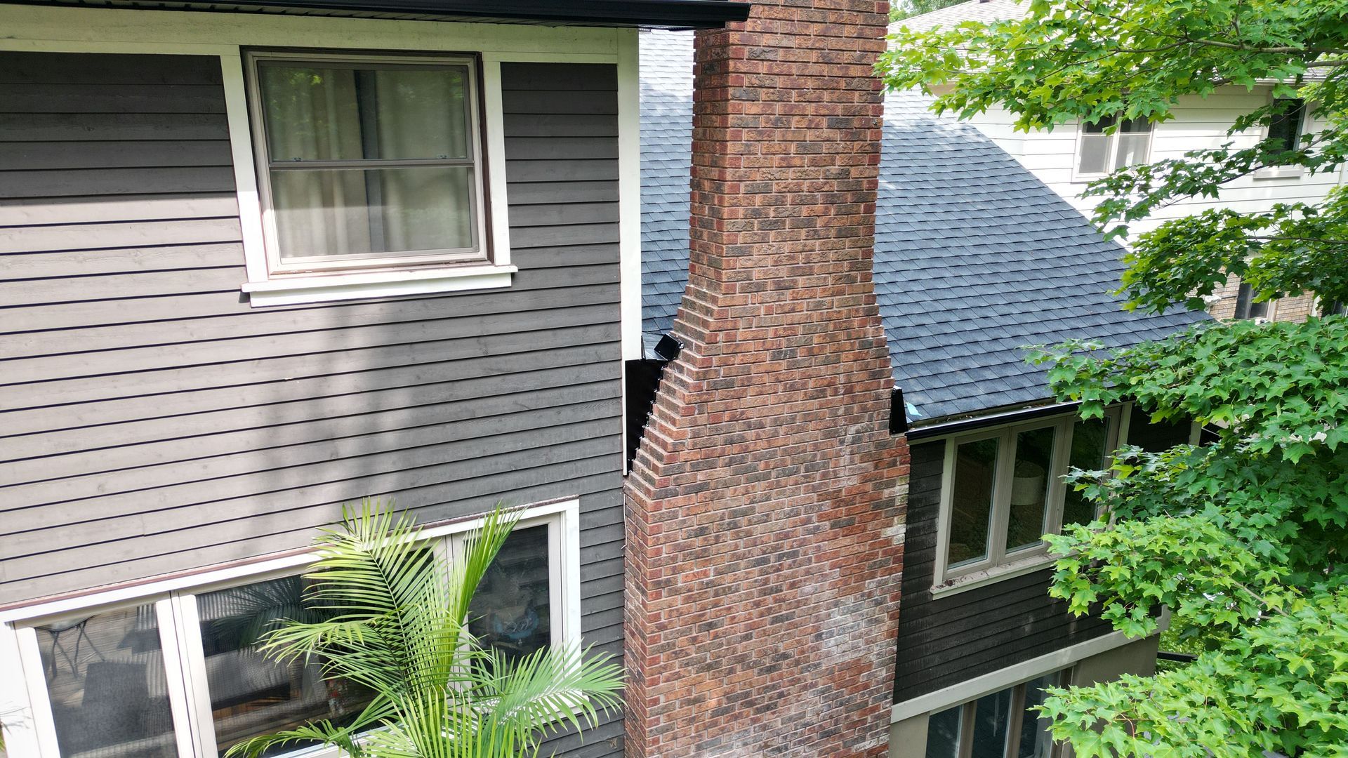 A brick chimney on the side of a house