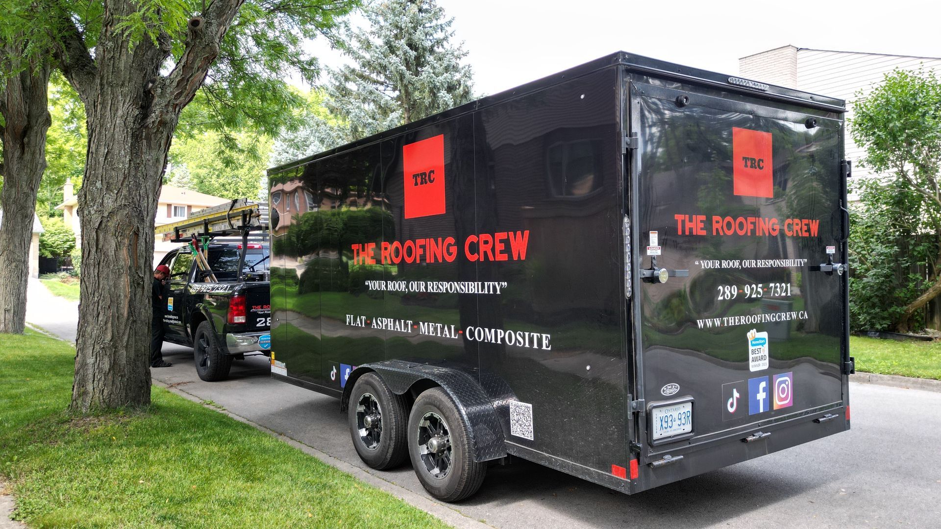 A black trailer with the roofing crew written on it