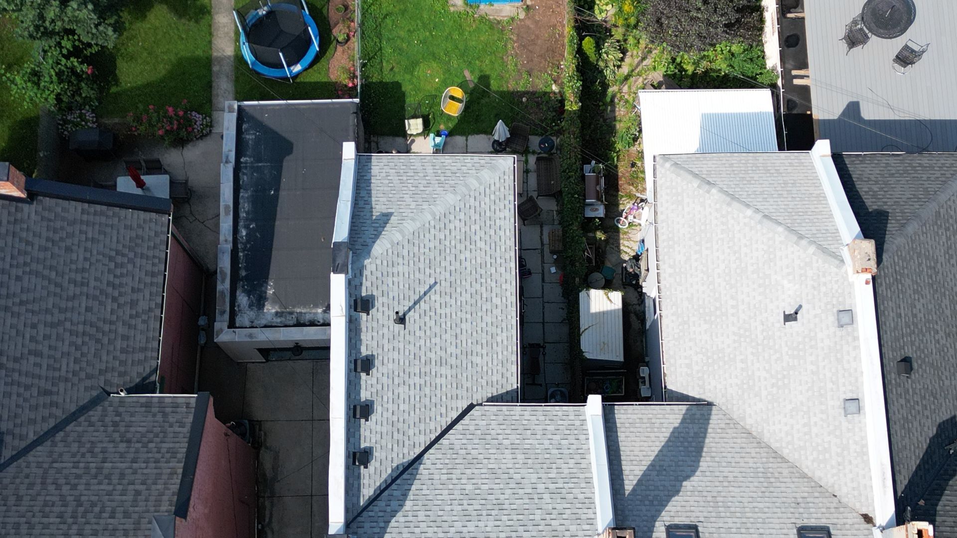 An aerial view of a house with a trampoline in the backyard