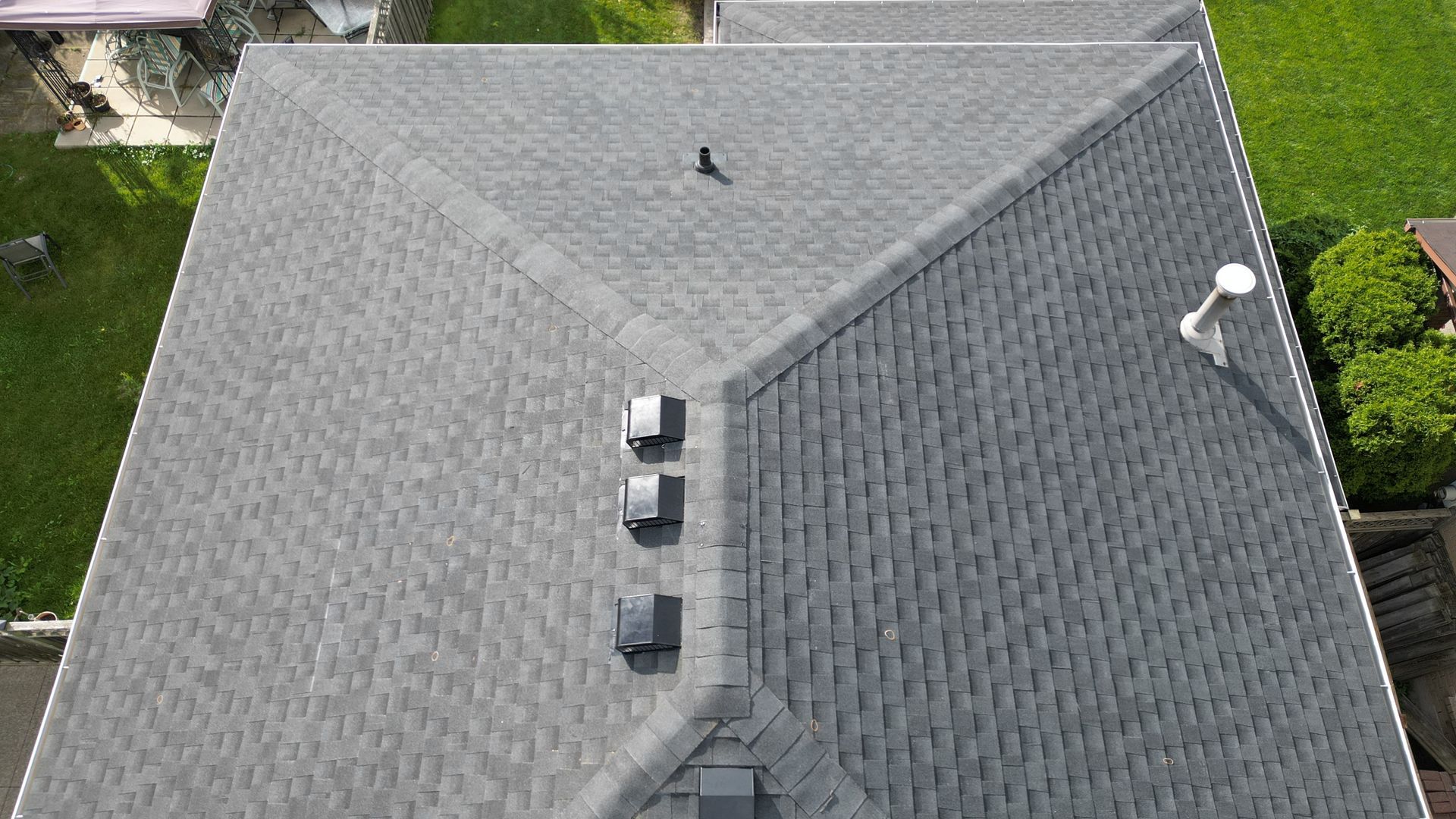 An aerial view of the roof of a house with a gray shingle roof.