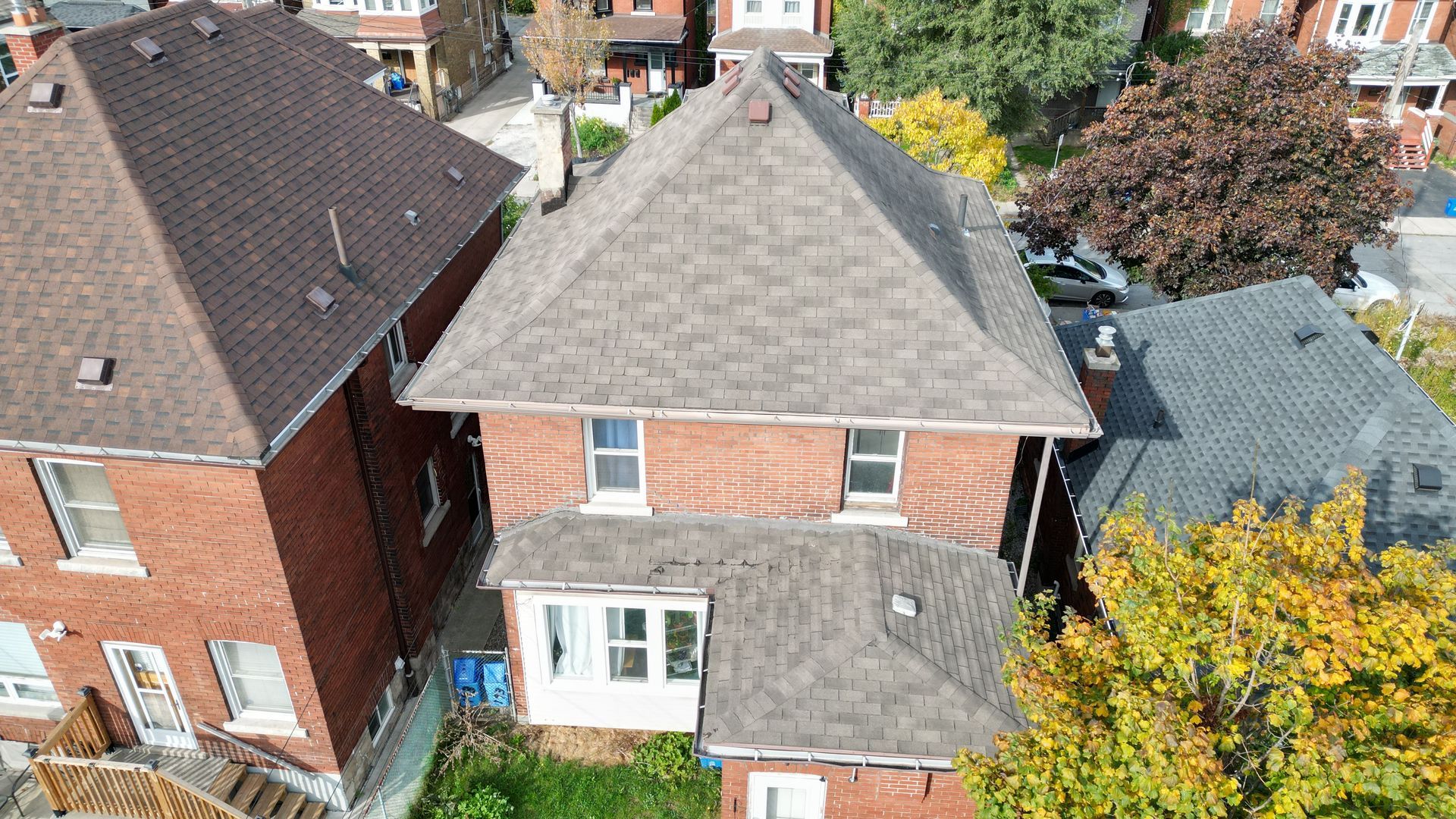 An aerial view of a brick house with a gray roof