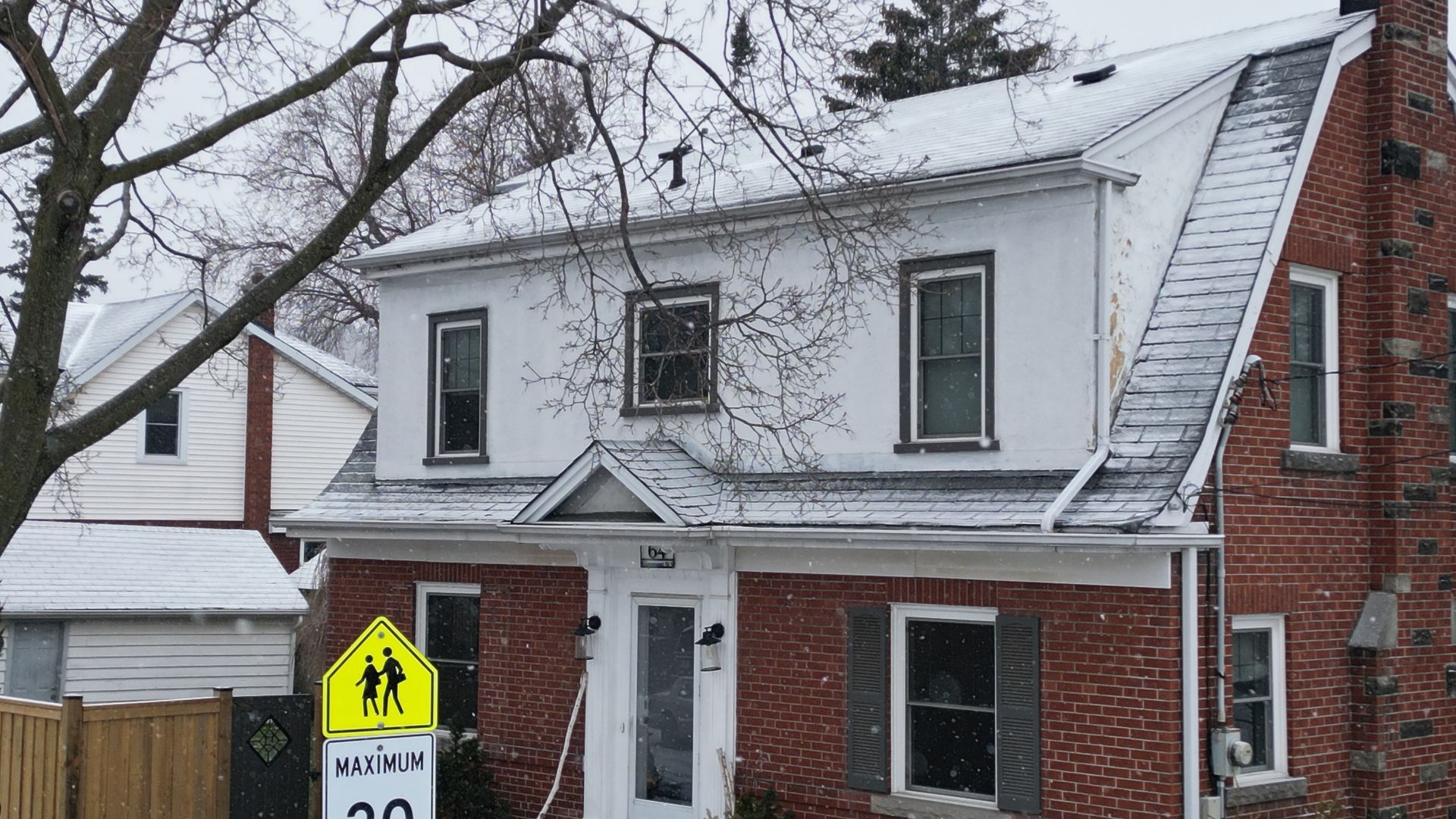 A brick house with a for sale sign in front of it