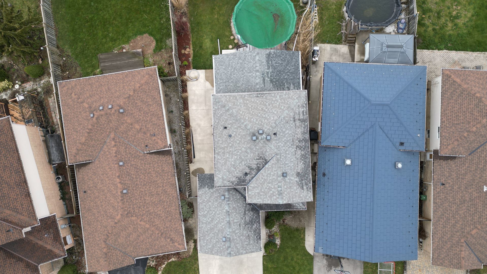 An aerial view of a row of houses with different colored roofs