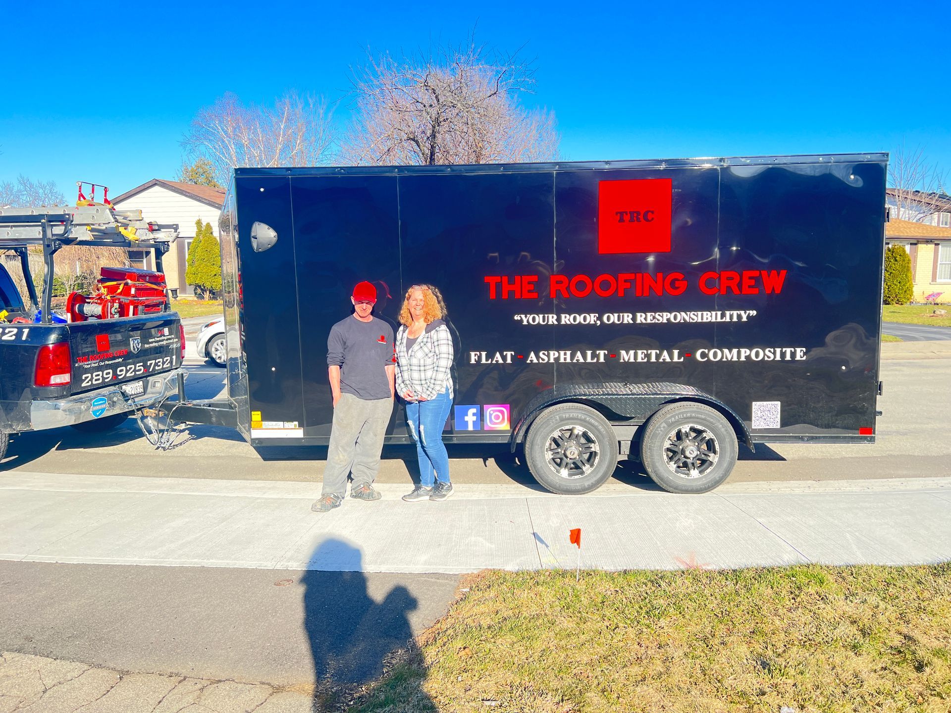 Two people standing in front of a trailer that says the roofing crew