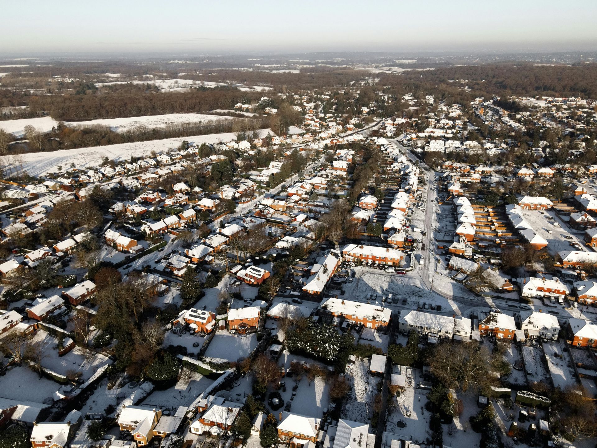 An aerial view of a residential area covered in snow