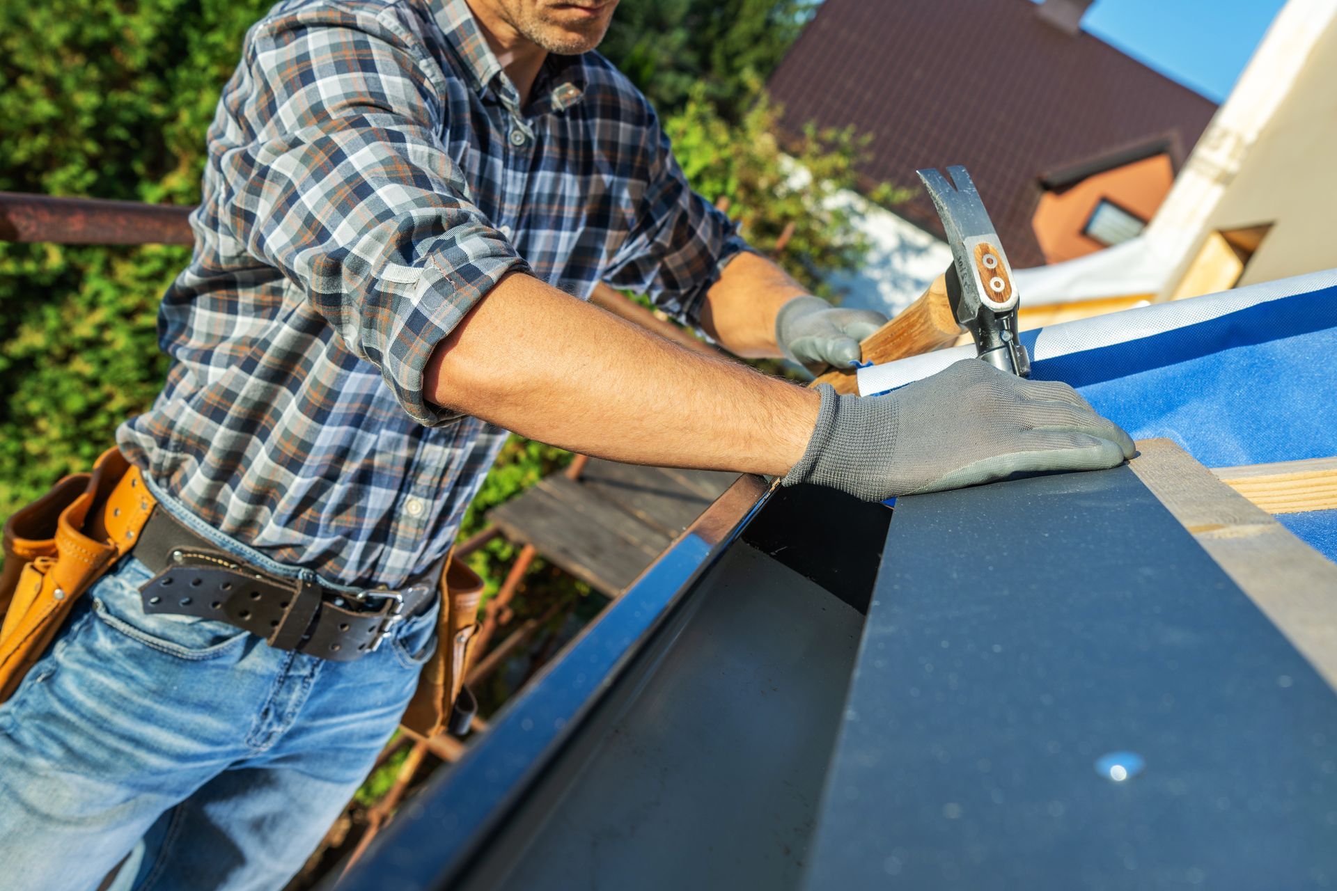A man is working on a roof with a hammer and nail.