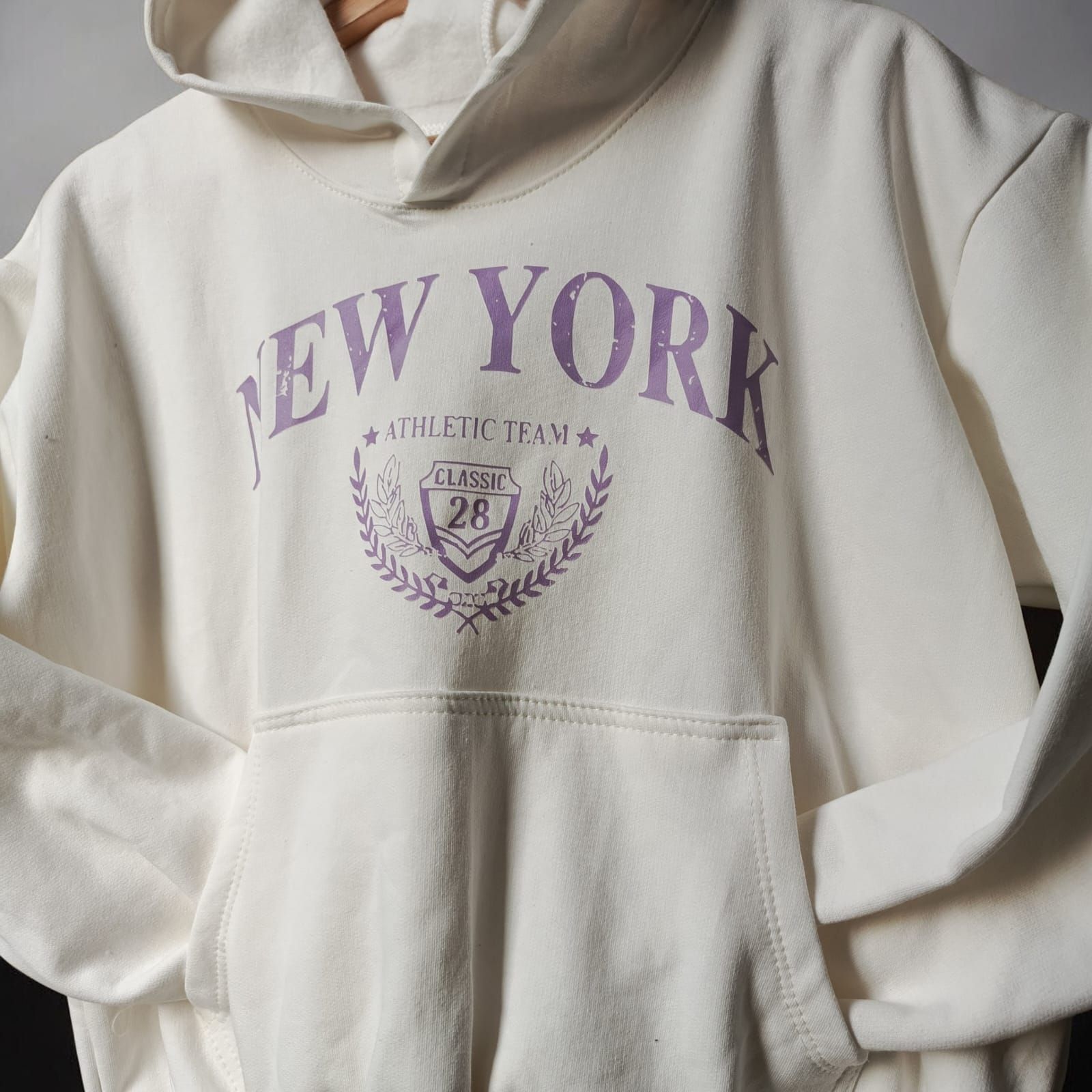 Sudadera con capucha color crema con el texto 