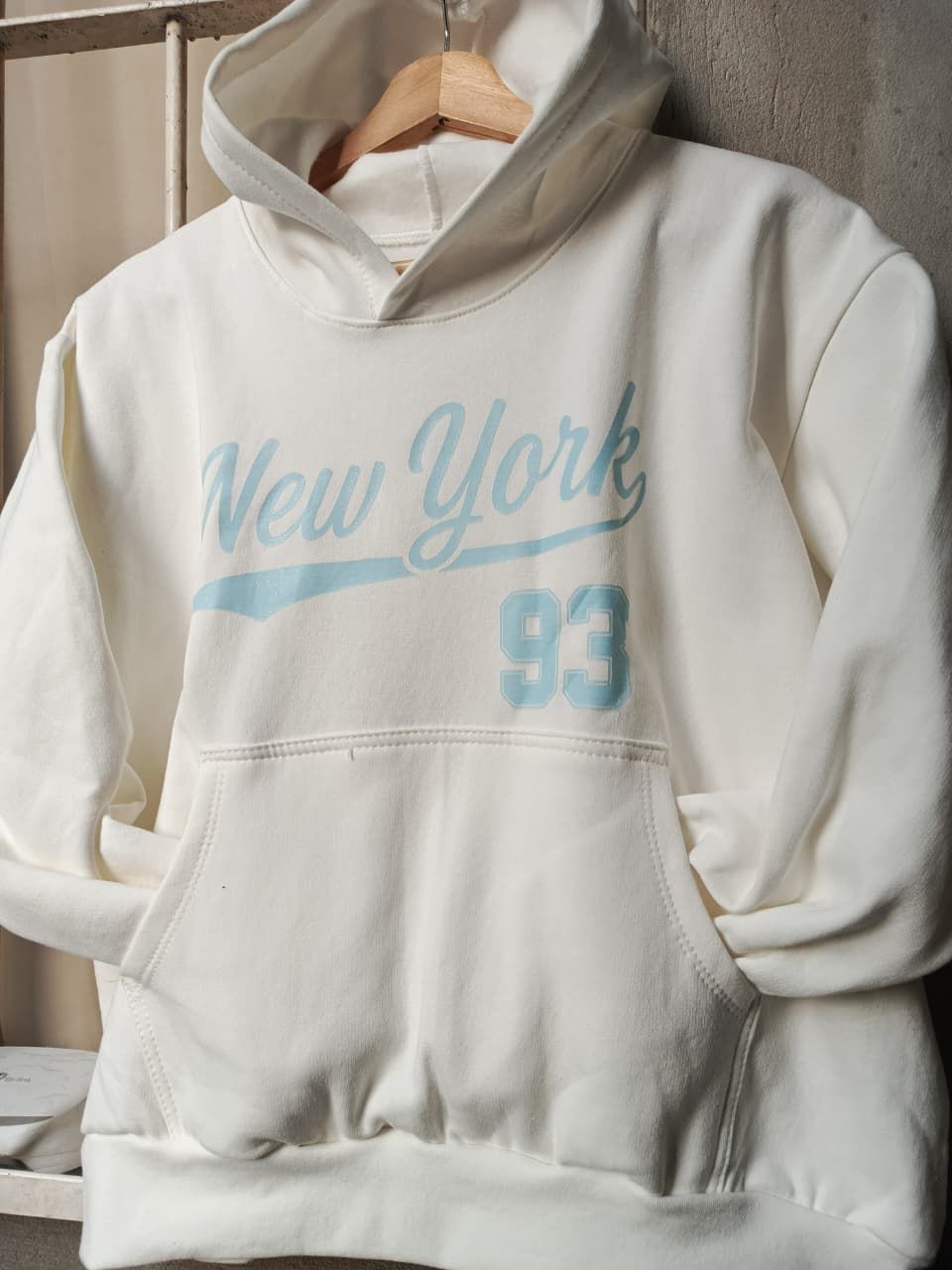 Sudadera con capucha color crema con el texto 