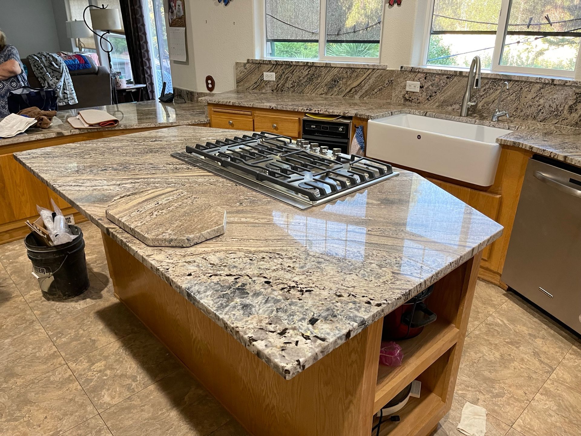 Kitchen island with granite countertop and built-in stovetop in a bright, modern kitchen