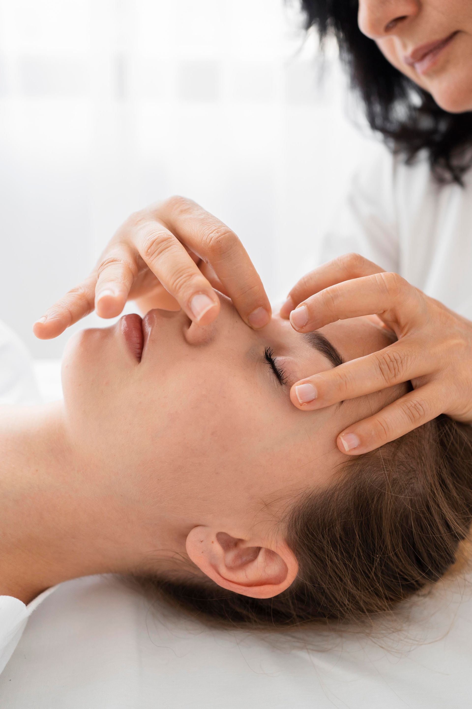 A woman is getting a massage on her face in a spa.