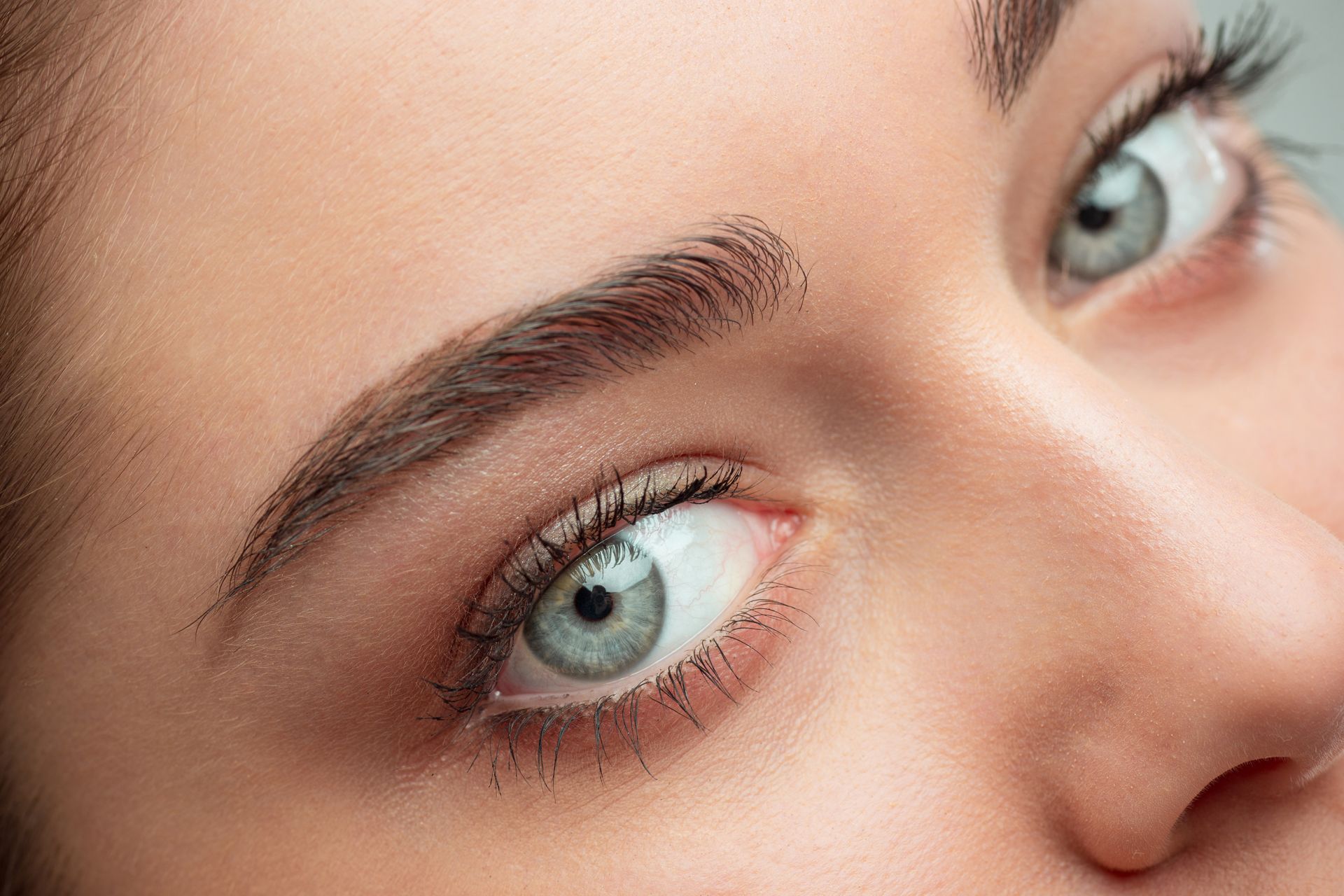 a close up of a woman 's blue eyes and eyebrows .