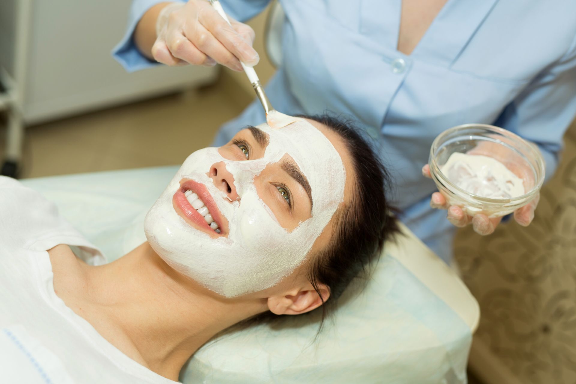 A woman is getting a facial treatment at a beauty salon.